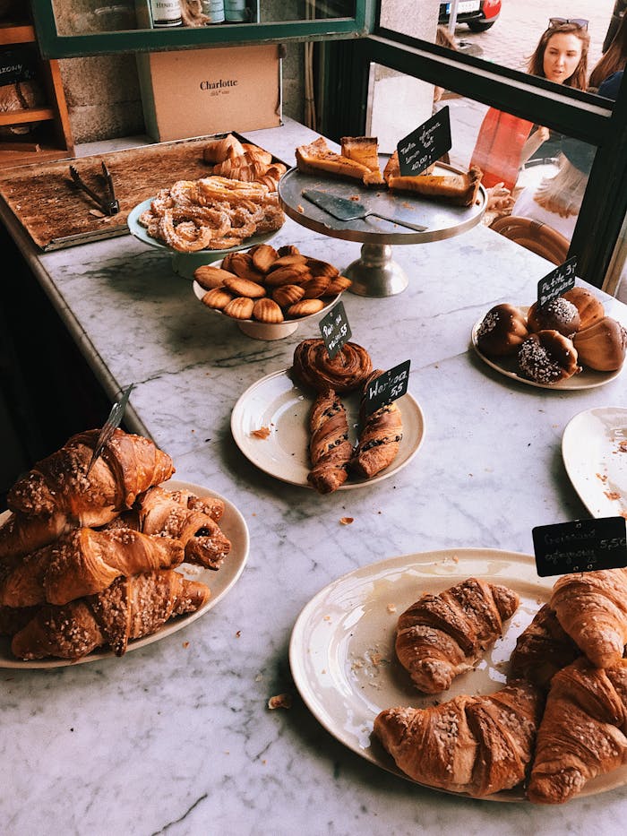 A mouth-watering display of various pastries including croissants and pastries in a bakery setting.