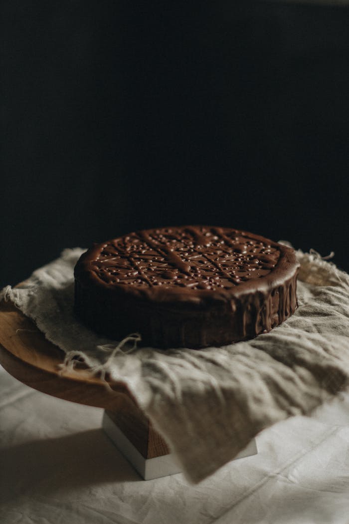 Delicious chocolate cake placed on rustic linen, ideal for dessert photography.